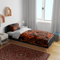 Orange and black Polynesian pattern duvet and pillowcases on bed frame