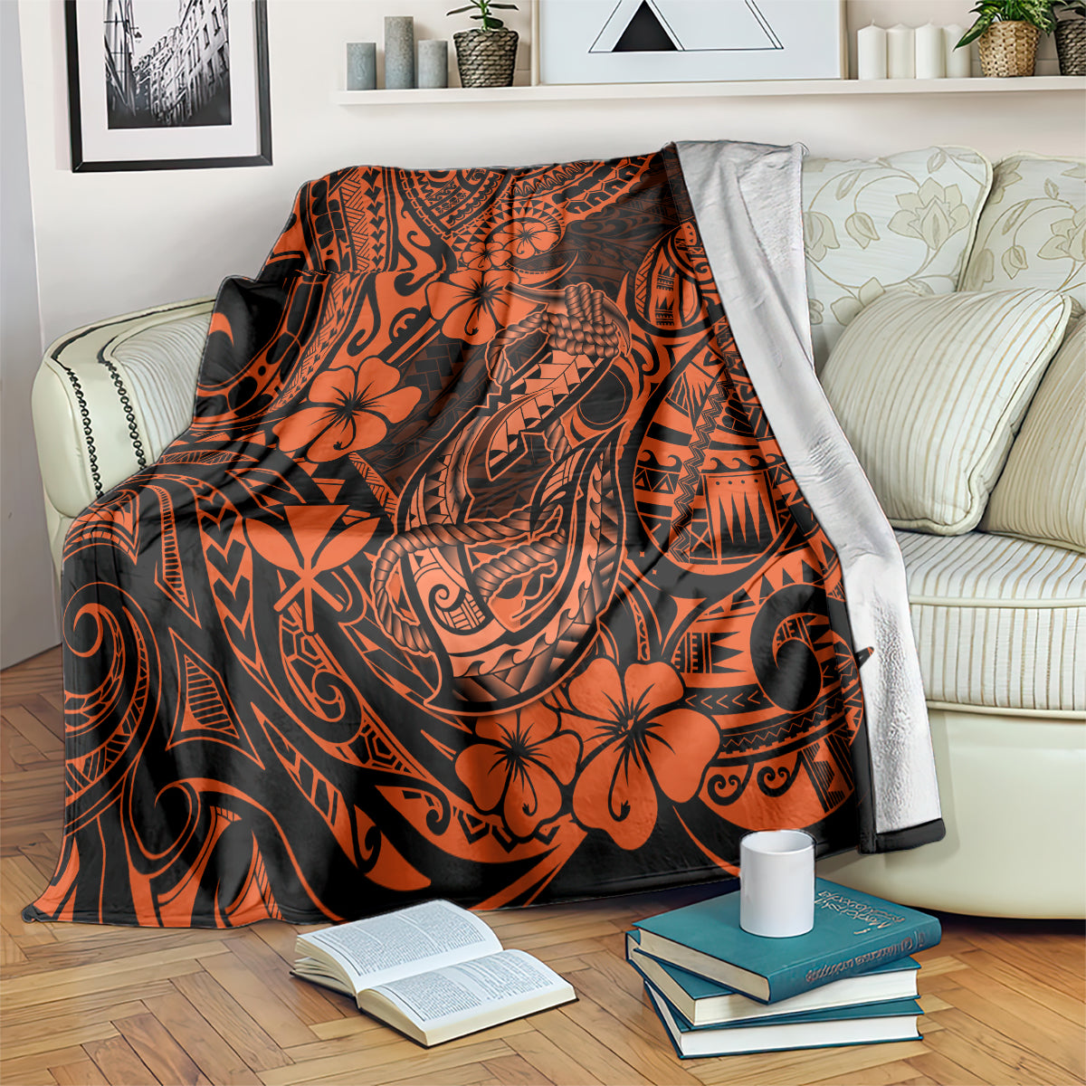 Orange and black Polynesian patterned fish hook blanket draped over a sofa arm
