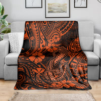Orange and black Polynesian fish hook blanket spread across a couch