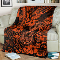 Orange and black fish hook patterned blanket draped over a sofa