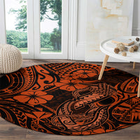 Orange round carpet with Polynesian fish hook design and black tribal motifs throughout.