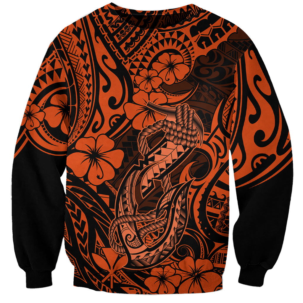 Orange and black graphic sweatshirt with Polynesian-style fish hook motif and floral details