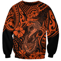 Orange and black graphic sweatshirt with Polynesian-style fish hook motif and floral details