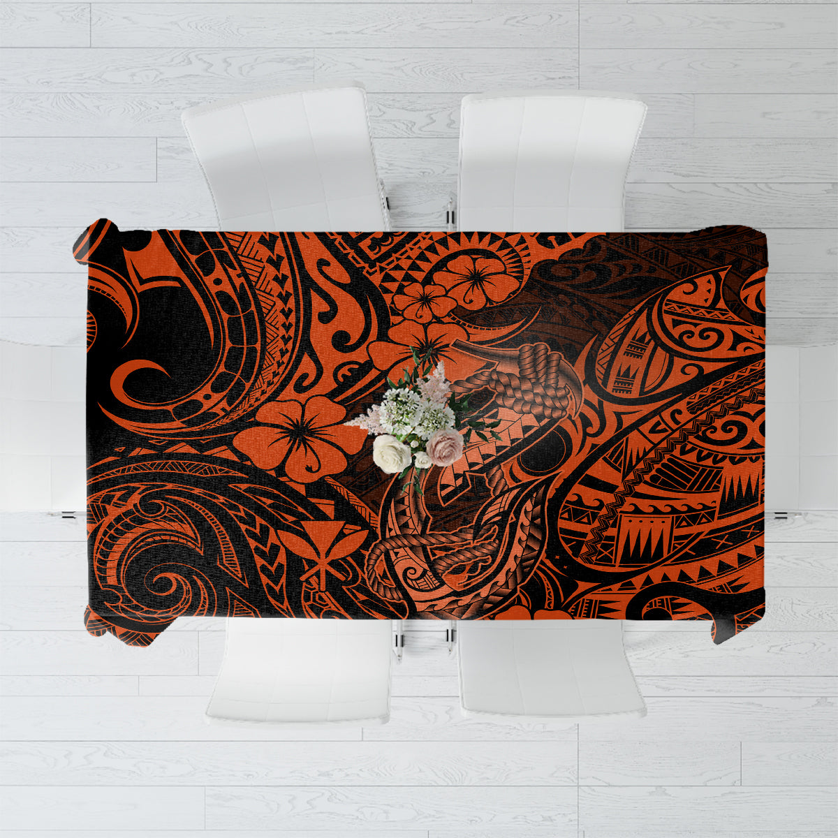 Orange and black Polynesian-style tablecloth with fish hook and floral motifs