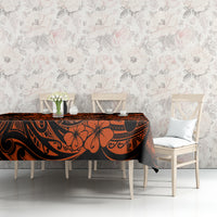 Orange and black Polynesian pattern tablecloth on rectangular table with leaf and hook designs