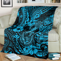 Blue hibiscus and fishhook throw blanket with tribal tattoo patterns over a living-room couch