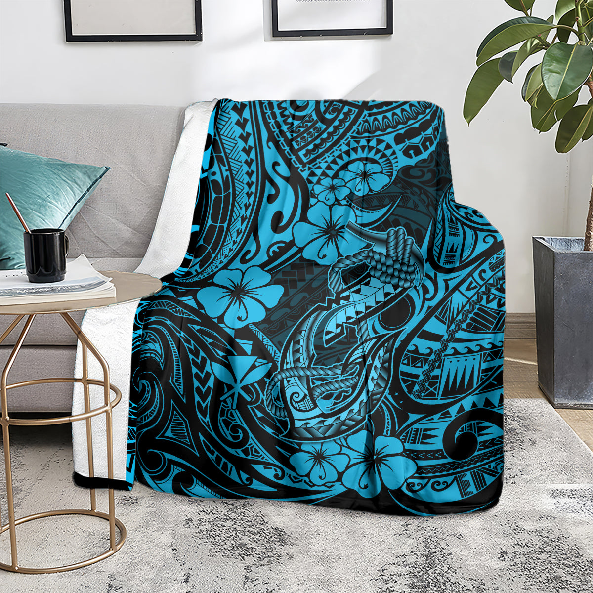 Blue tribal throw blanket draped over an arm of a sofa, hibiscus and fishhook graphics