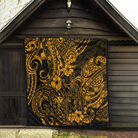 Gold and black Polynesian-pattern quilt hanging indoors, with intricate swirls and floral motifs