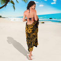 Gold and black polynesian sarong worn like a dress with neck tie and swirl print