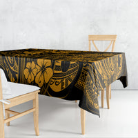 Gold and black patterned tablecloth draped over a table with detailed island motifs.