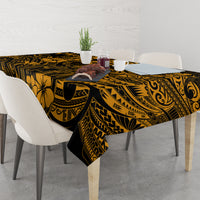 Gold and black Polynesian tablecloth with scrolling shapes and floral motif border.