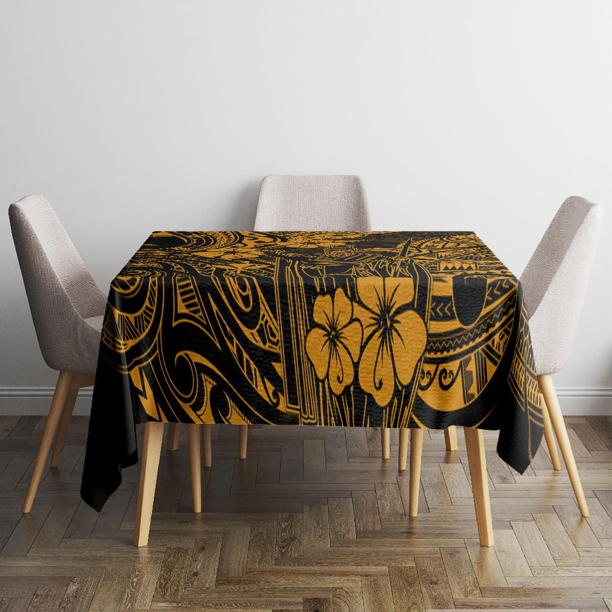 Black and gold patterned tablecloth with hibiscus and geometric swirl details on tabletop.