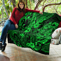 Green Polynesian pattern quilt draped on a couch cushion, held by a person