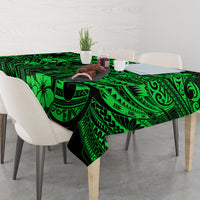 Green polynesian tablecloth on dining table, featuring geometric borders and flower shapes