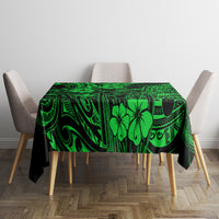 Green polynesian tablecloth laid on table, dark swirls and island flower motifs