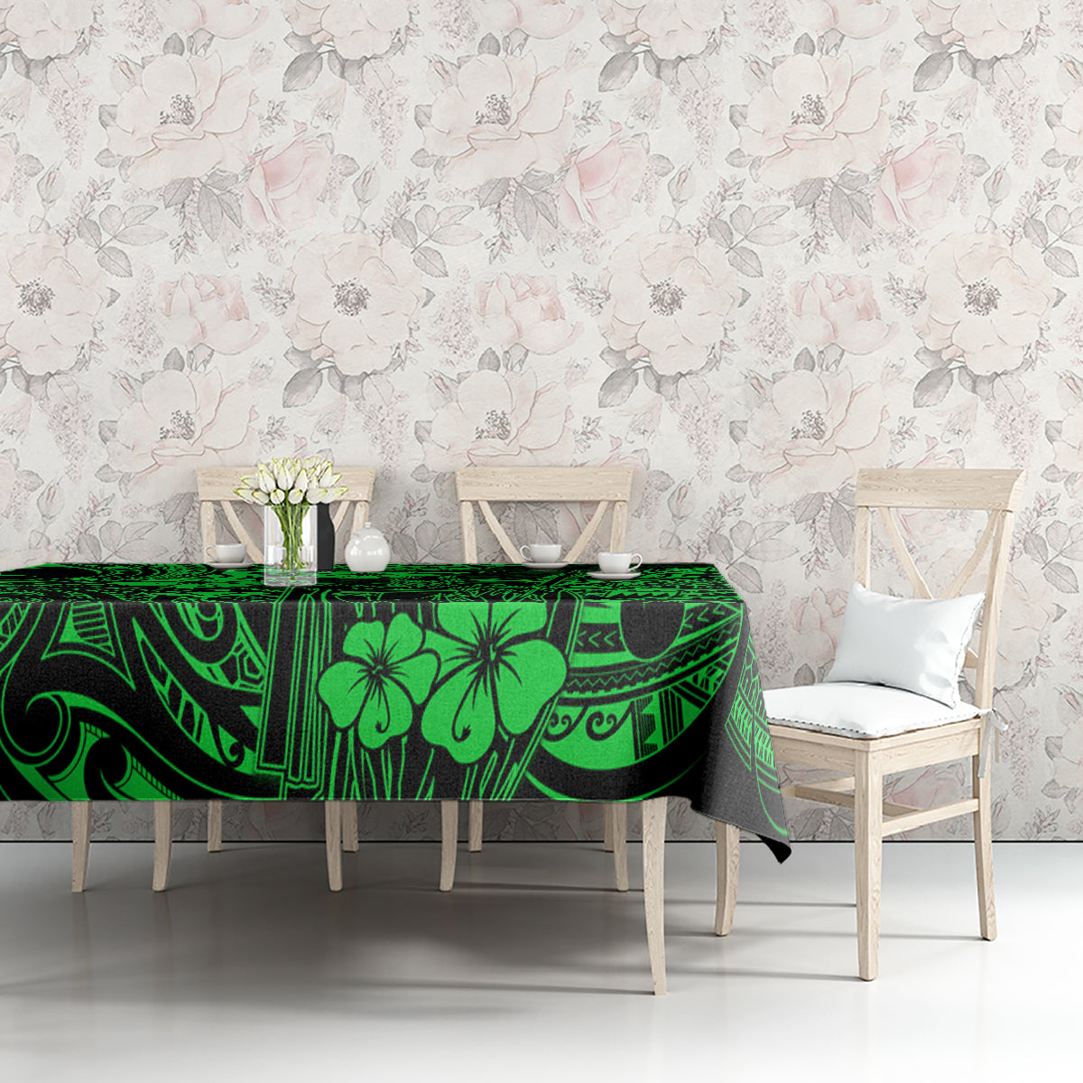 Green polynesian tablecloth on table, patterned with geometric lines and hibiscus-style flowers