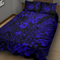 Polynesian pattern quilt bed set in navy blue with matching pillow shams on a bed.