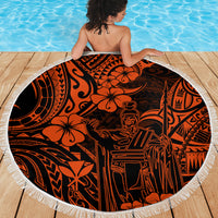 Orange circular Polynesian pattern beach blanket with white fringe on wooden deck