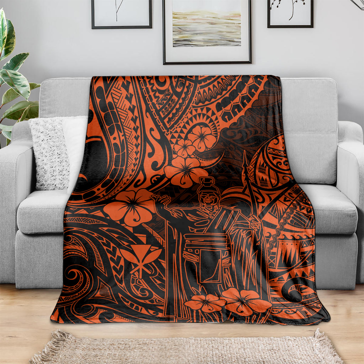 Orange and black Polynesian pattern throw blanket draped over gray sofa, floral and tribal symbols