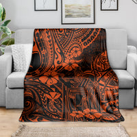 Orange and black Polynesian pattern throw blanket draped over gray sofa, floral and tribal symbols