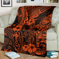 Orange and black Polynesian pattern blanket draped on light couch with hibiscus flowers and carvings