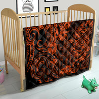 Orange and black Polynesian quilt on child bed, with tiki and floral swirl designs