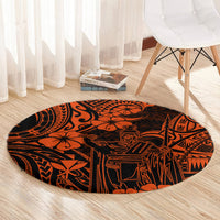 Round orange and black Polynesian patterned area rug on light wood floor with bold silhouettes