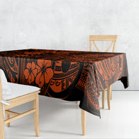 Orange and black Polynesian patterned tablecloth draped over dining table