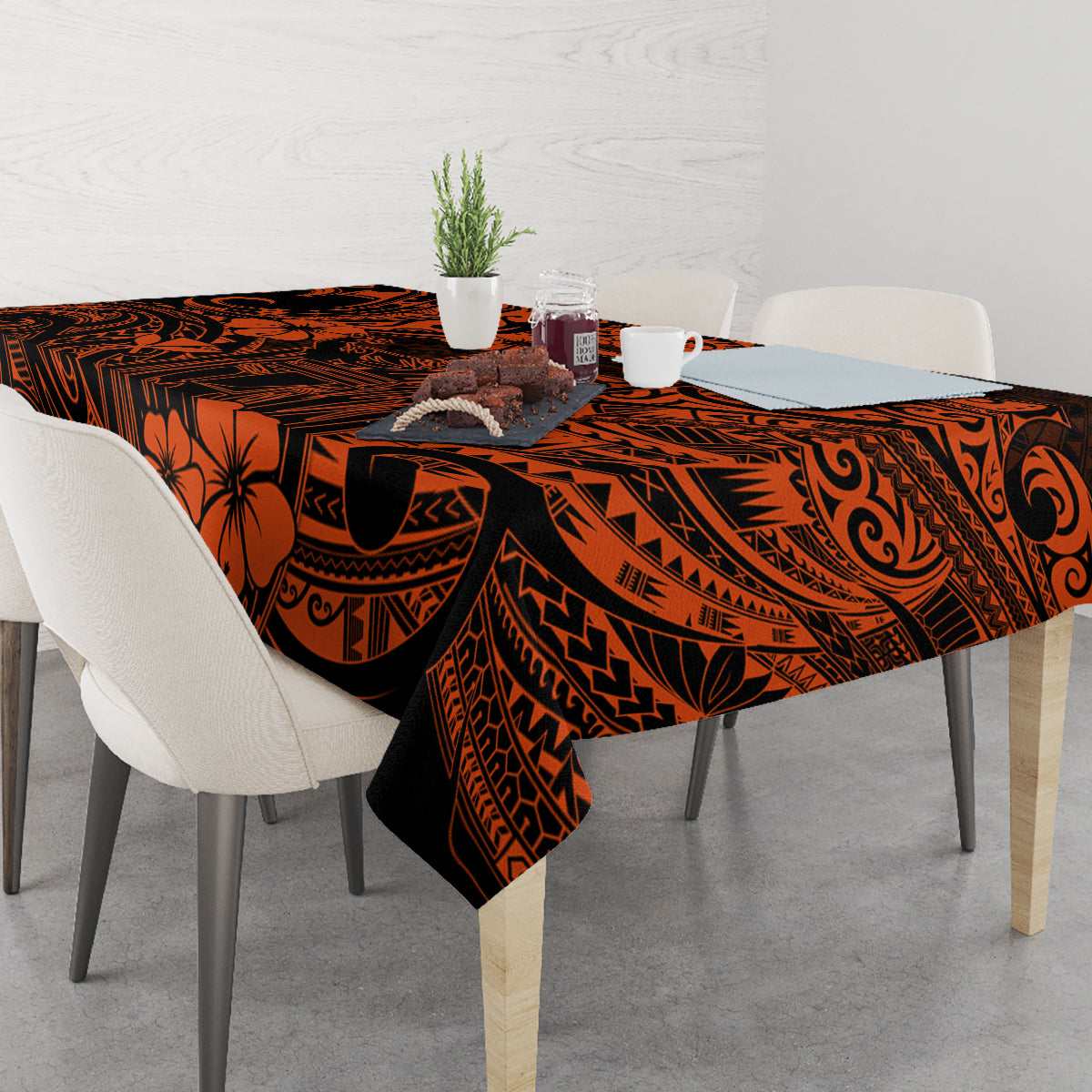 Orange and black Polynesian patterned tablecloth on table with place settings