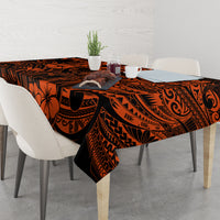 Orange and black Polynesian patterned tablecloth on table with place settings