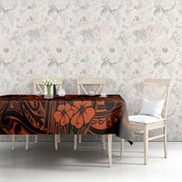 Orange and black Polynesian patterned tablecloth on table with chair seating