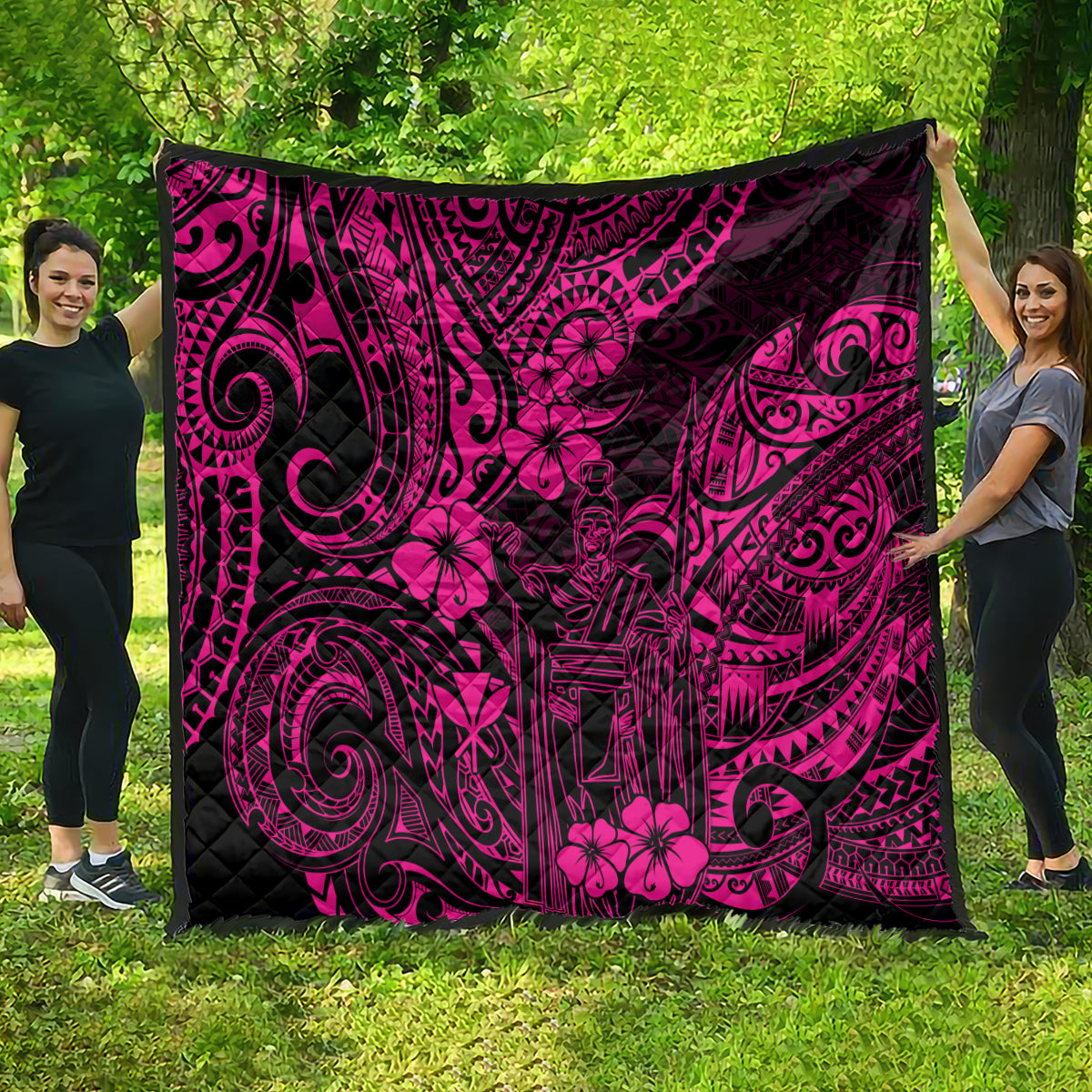 Pink Polynesian quilt spread out outdoors, featuring dark swirl and flower motifs