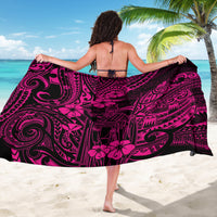 Pink sarong worn on back, featuring black Polynesian motifs and hibiscus flowers