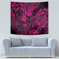 Pink Polynesian tapestry with dark tribal masks, swirls, and flower motifs, wall-hung