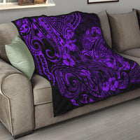 Purple and black Polynesian pattern quilt blanket on a gray sofa