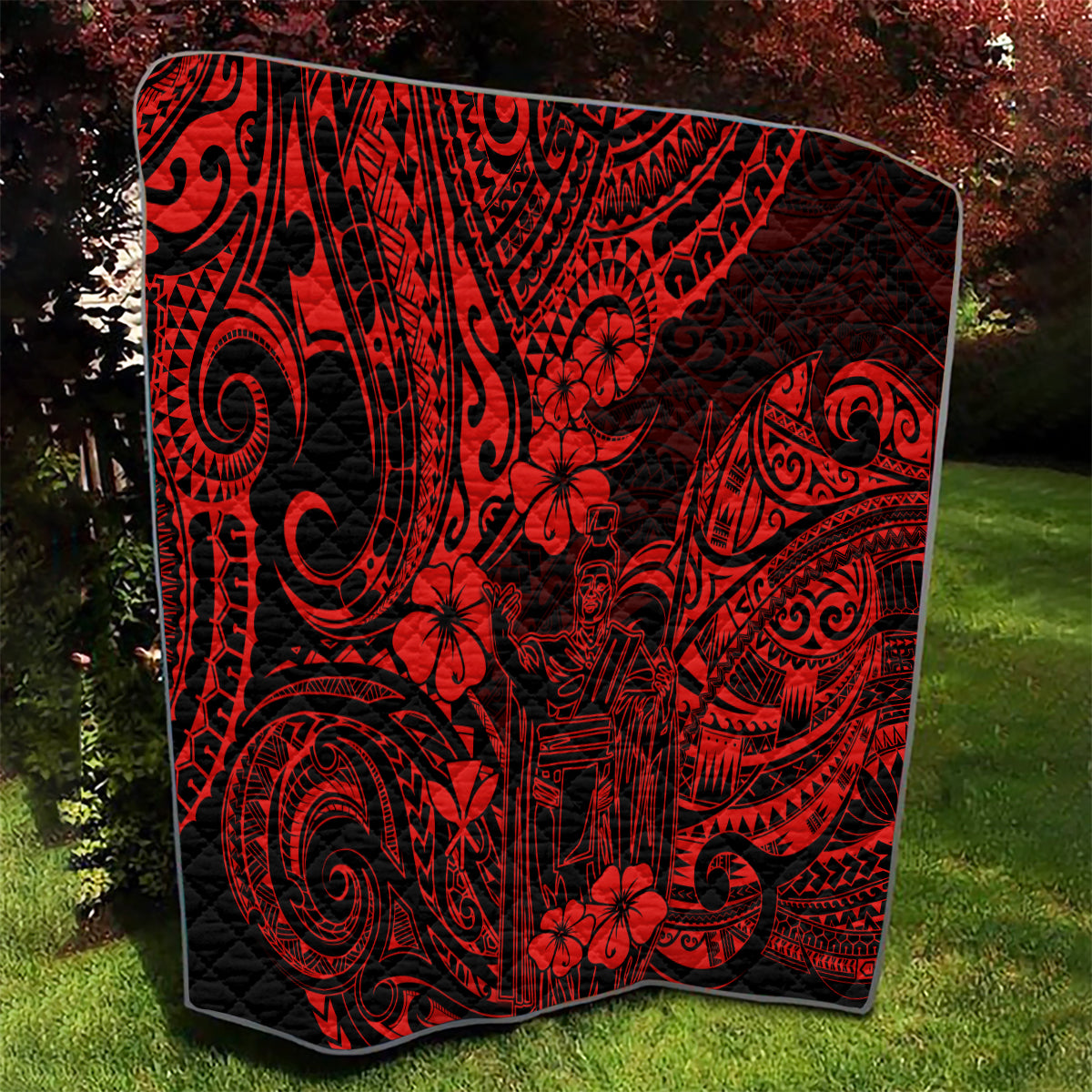 Red and black Polynesian pattern quilt with stylized swirls and floral motifs