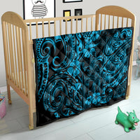 Blue Polynesian pattern quilt in a wooden baby crib, with dark border and tiki motifs.