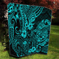 Turquoise Polynesian pattern quilt draped on lawn, black border and ornate icons
