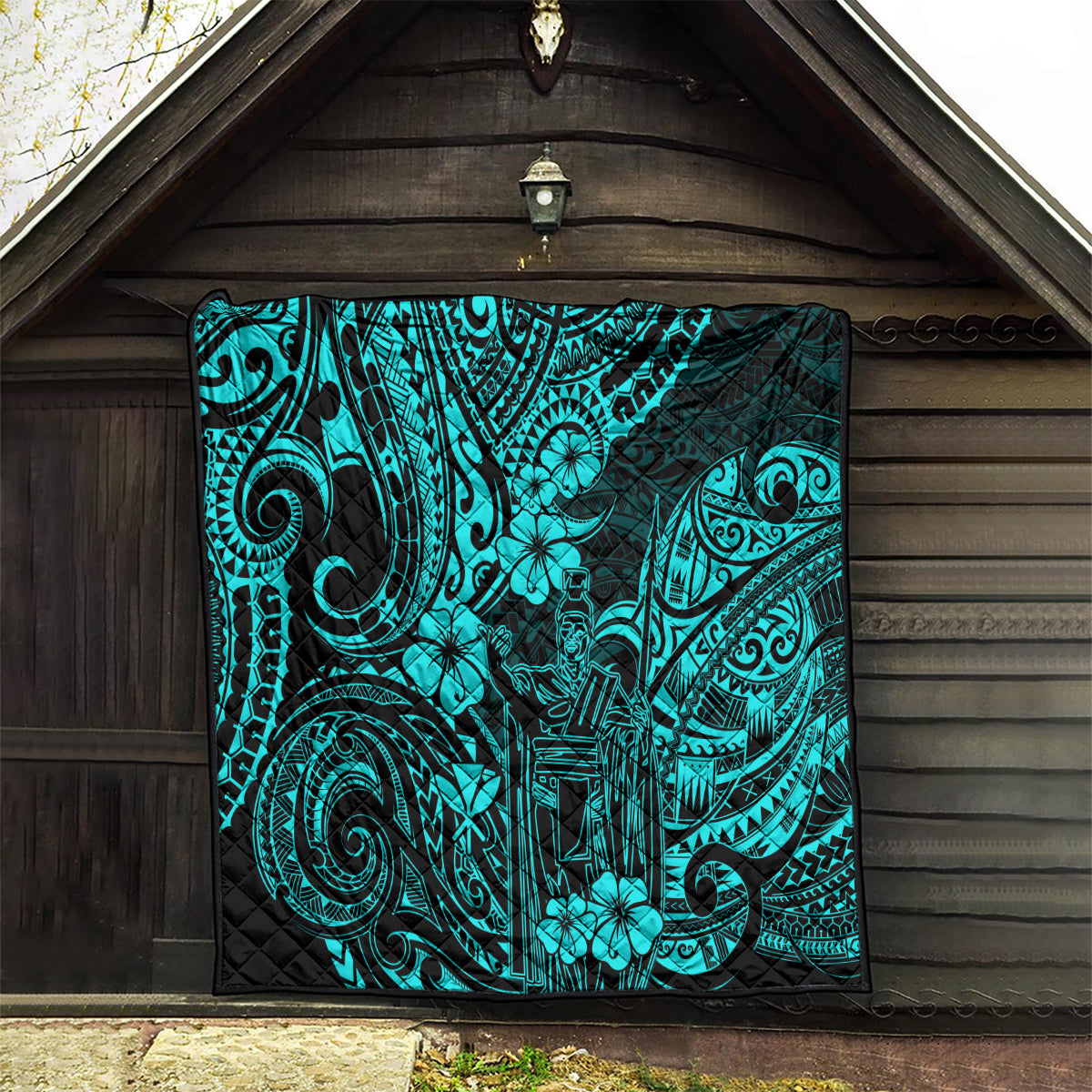 Turquoise Polynesian pattern quilt hanging on outdoor wall under roof eave
