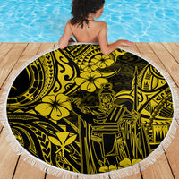 Person draped in round beach blanket with yellow and black Polynesian pattern and white fringe.