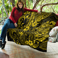 Yellow-and-black Polynesian pattern quilt laid on a patio bench with person