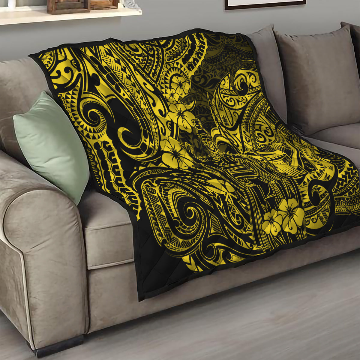 Yellow-and-black Polynesian pattern quilt folded on a living room sofa