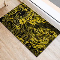 Yellow rubber doormat featuring black ornamental swirls, tiki figure, and floral motifs