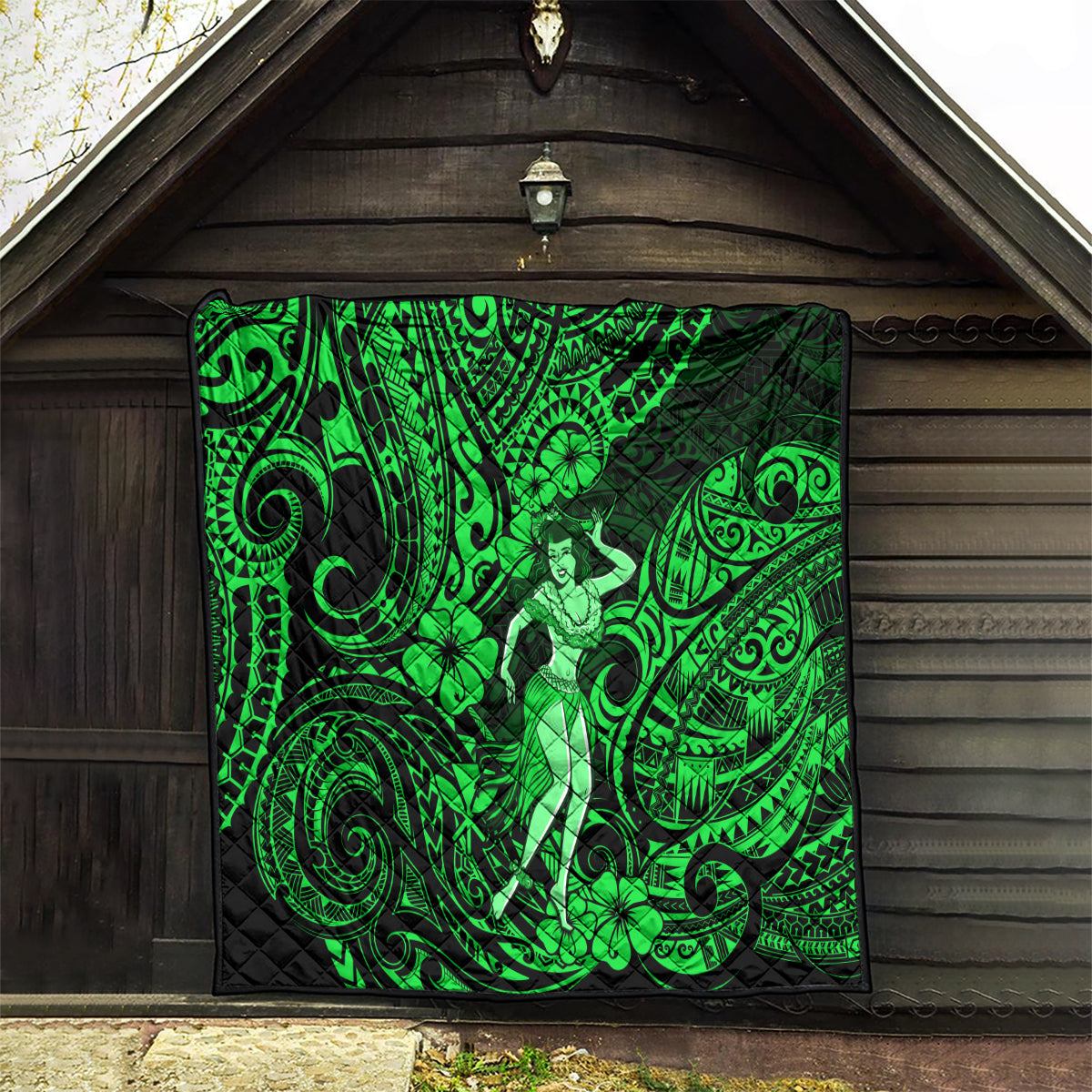 Green Polynesian hula girl quilt hanging on a wooden wall with ornate swirl patterns