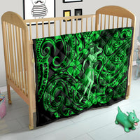 Green Polynesian hula girl quilt on a baby bed with swirling tiki and clover details