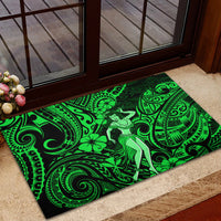 Green rubber doormat with hula dancer and Polynesian tribal designs at entry step.