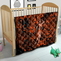 Orange and black Polynesian hula girl quilt on a crib with bold tribal swirls