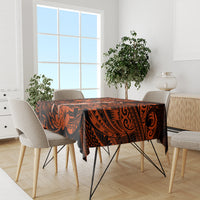 Orange and black Polynesian tablecloth on dining table with beige chair backs