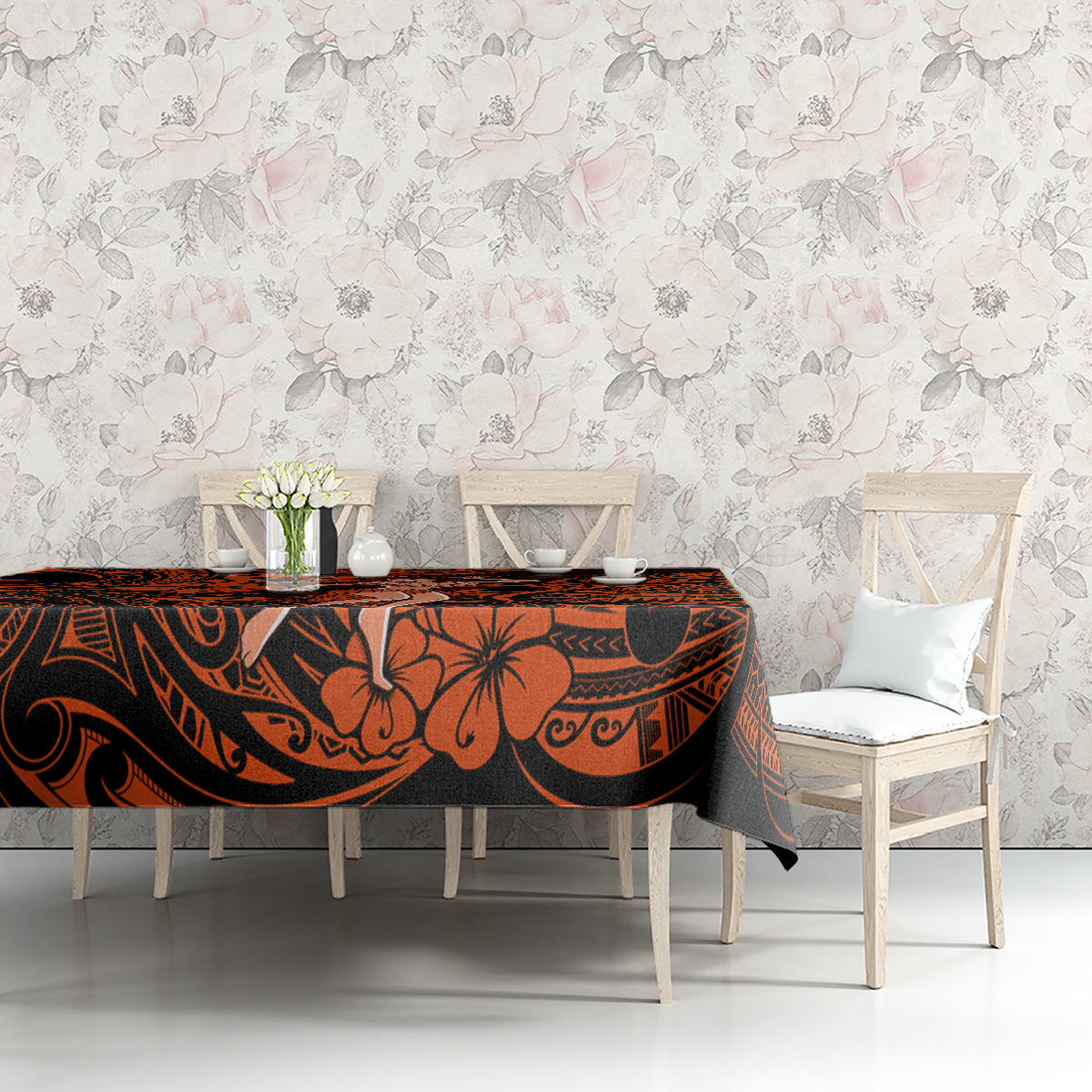 Orange and black Polynesian patterned tablecloth on table with two chairs