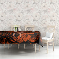 Orange and black Polynesian patterned tablecloth on table with two chairs